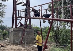 Personel TNI dan Masyarakat Cat Besi Tiang Jembatan Perintis di Desa Serasah
